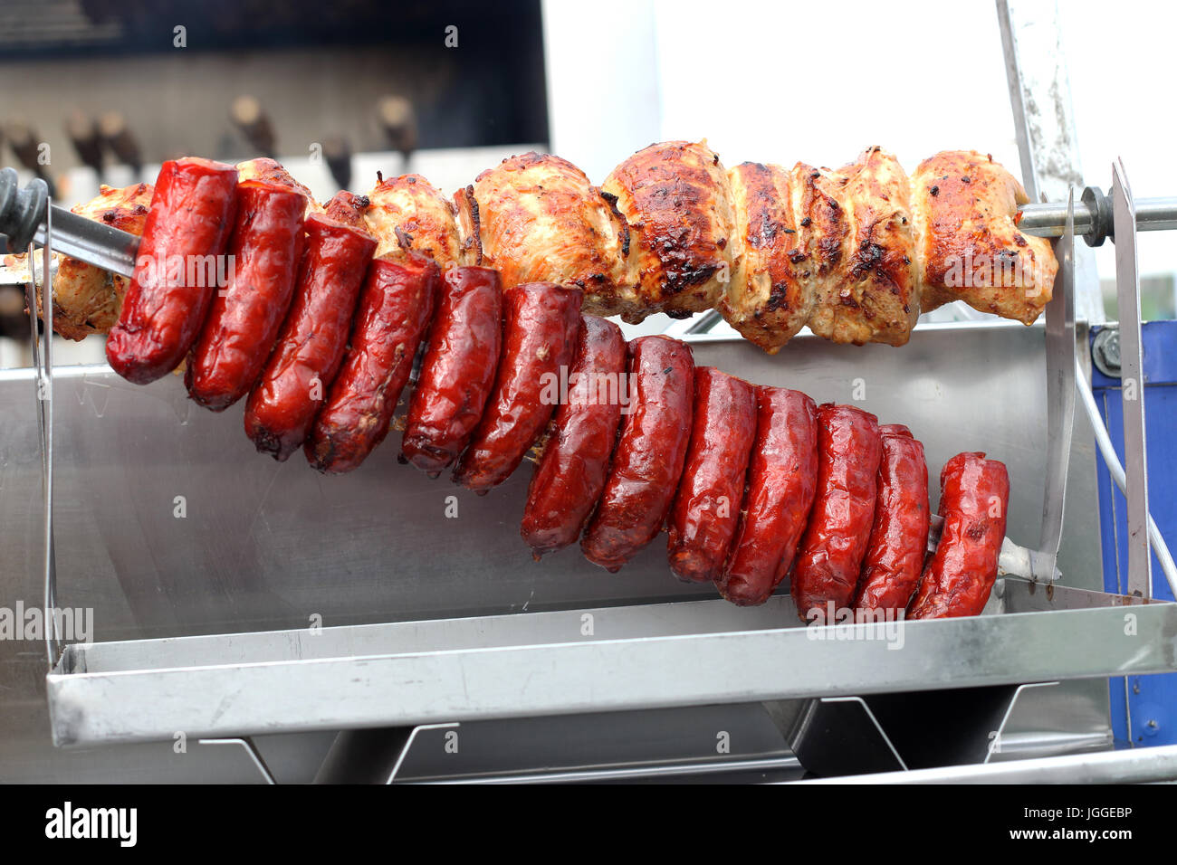 Il chorizo salsicce e polli arrosto su carbone di legna spiedo girarrosto barbecue Foto Stock