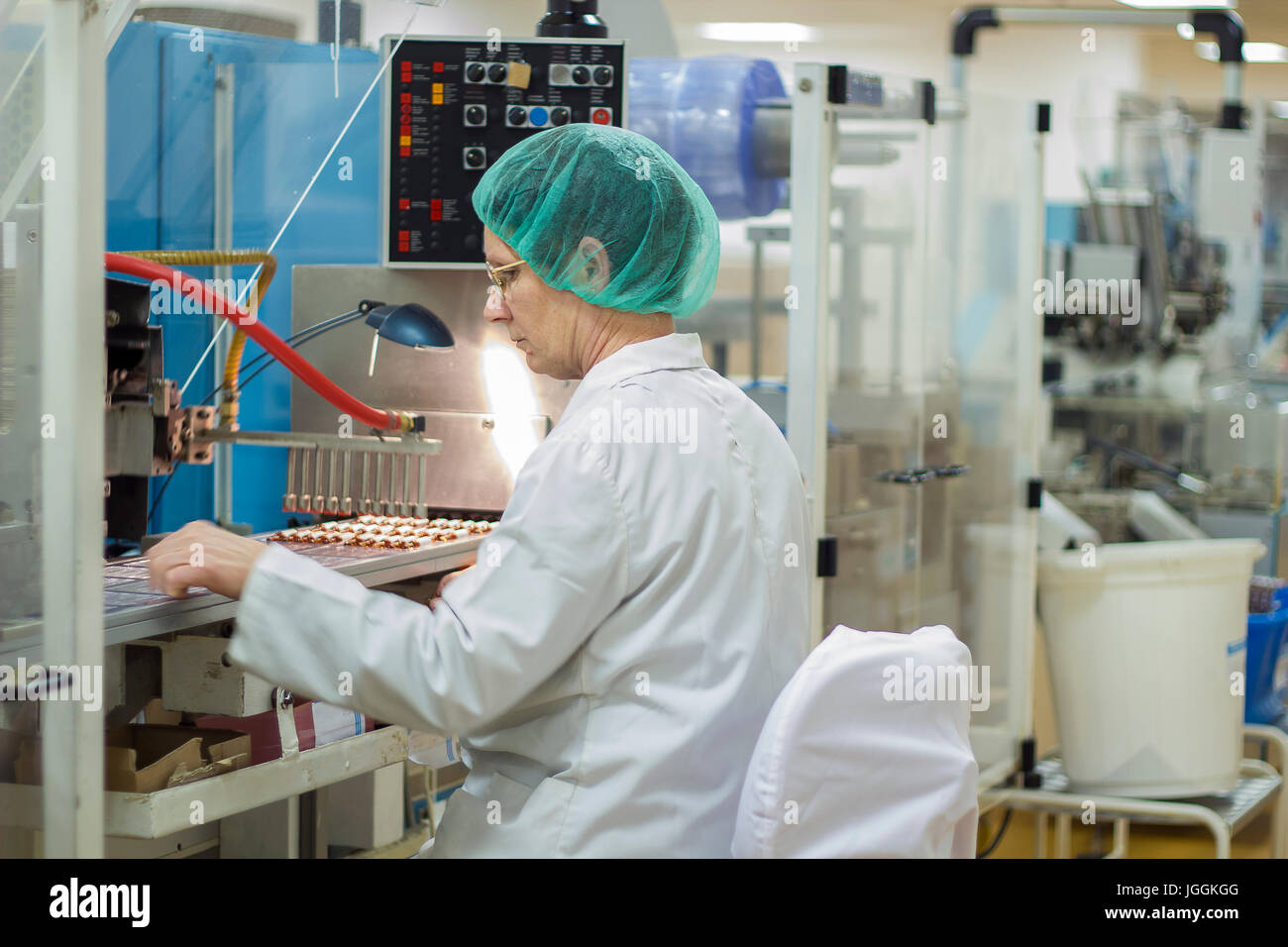 Il braccio robotico fiale di sollevamento alla linea di confezionamento in fabbrica farmaceutica. Foto Stock