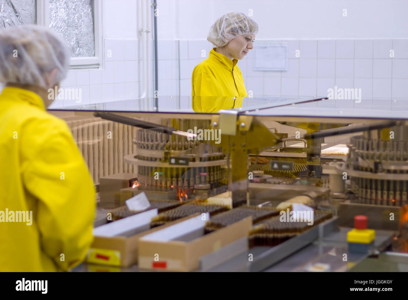 Due lavoratori farmaceutica protettivo indossando indumenti da lavoro. I lavoratori di sesso femminile in fabbrica farmaceutica. Foto Stock