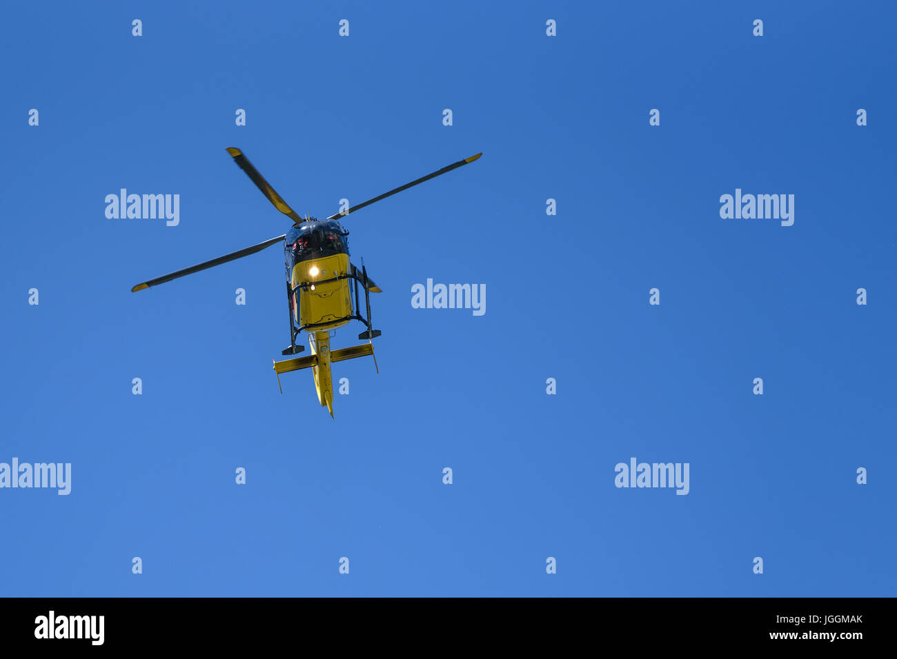 Generico elicottero giallo utilizzato per combattere gli incendi e le operazioni di soccorso sul cielo blu di sfondo - Angelo basso vista. Foto Stock