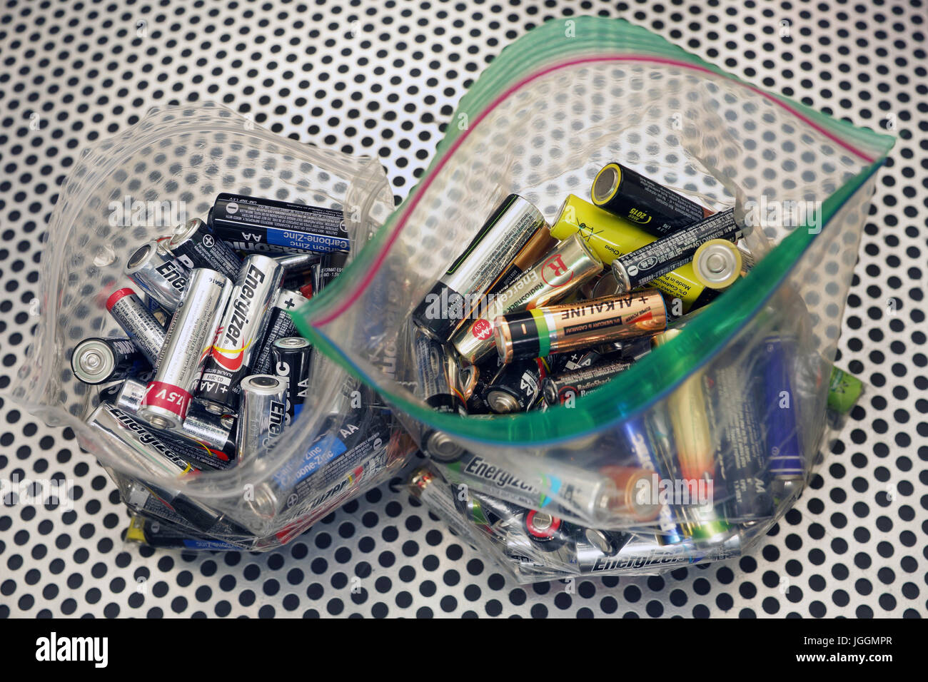 Il contenitore di riciclaggio piena di doppia uso delle batterie AA Foto Stock