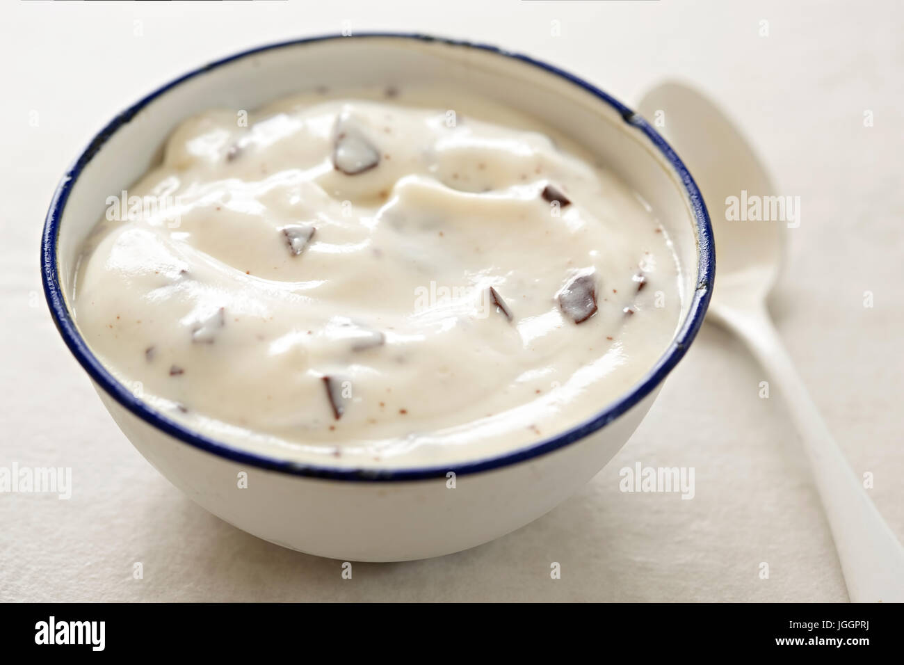 Stracciatella yogurt in una piccola ciotola con cucchiaino di colore bianco Foto Stock