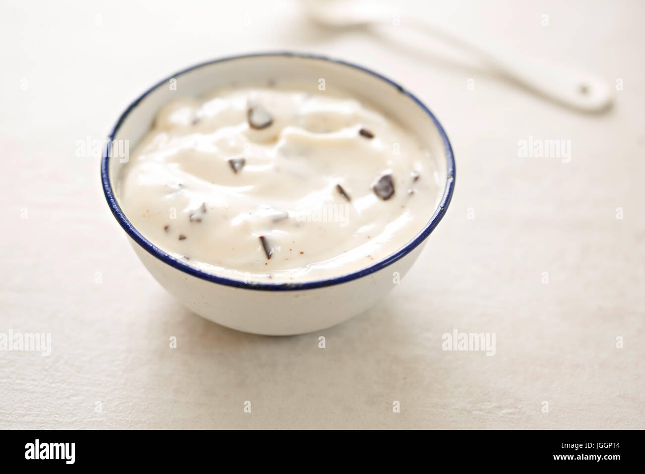 Stracciatella yogurt in una piccola ciotola con cucchiaino di colore bianco Foto Stock