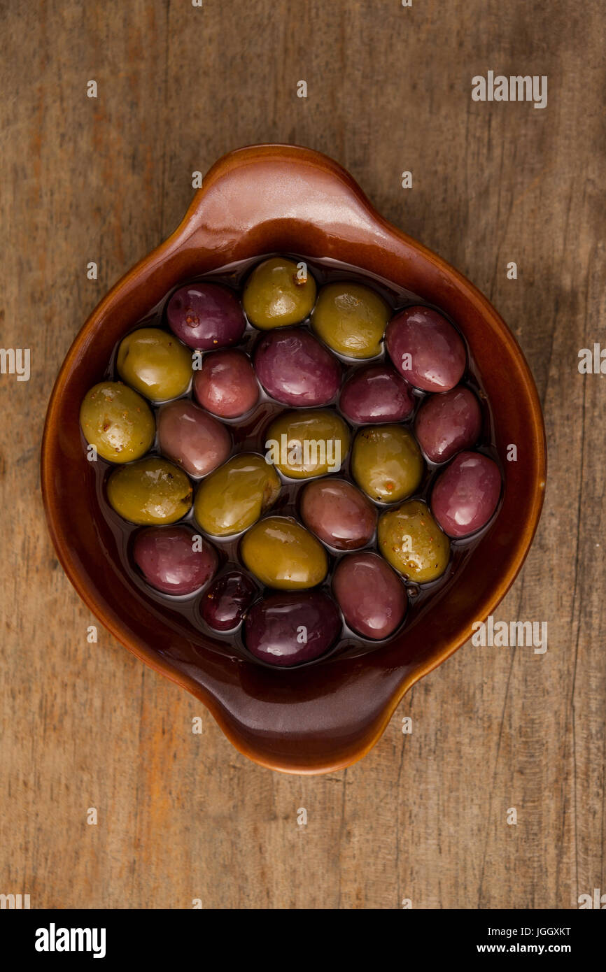 Vista aerea di olive con olio nel contenitore di legno sul tavolo Foto Stock