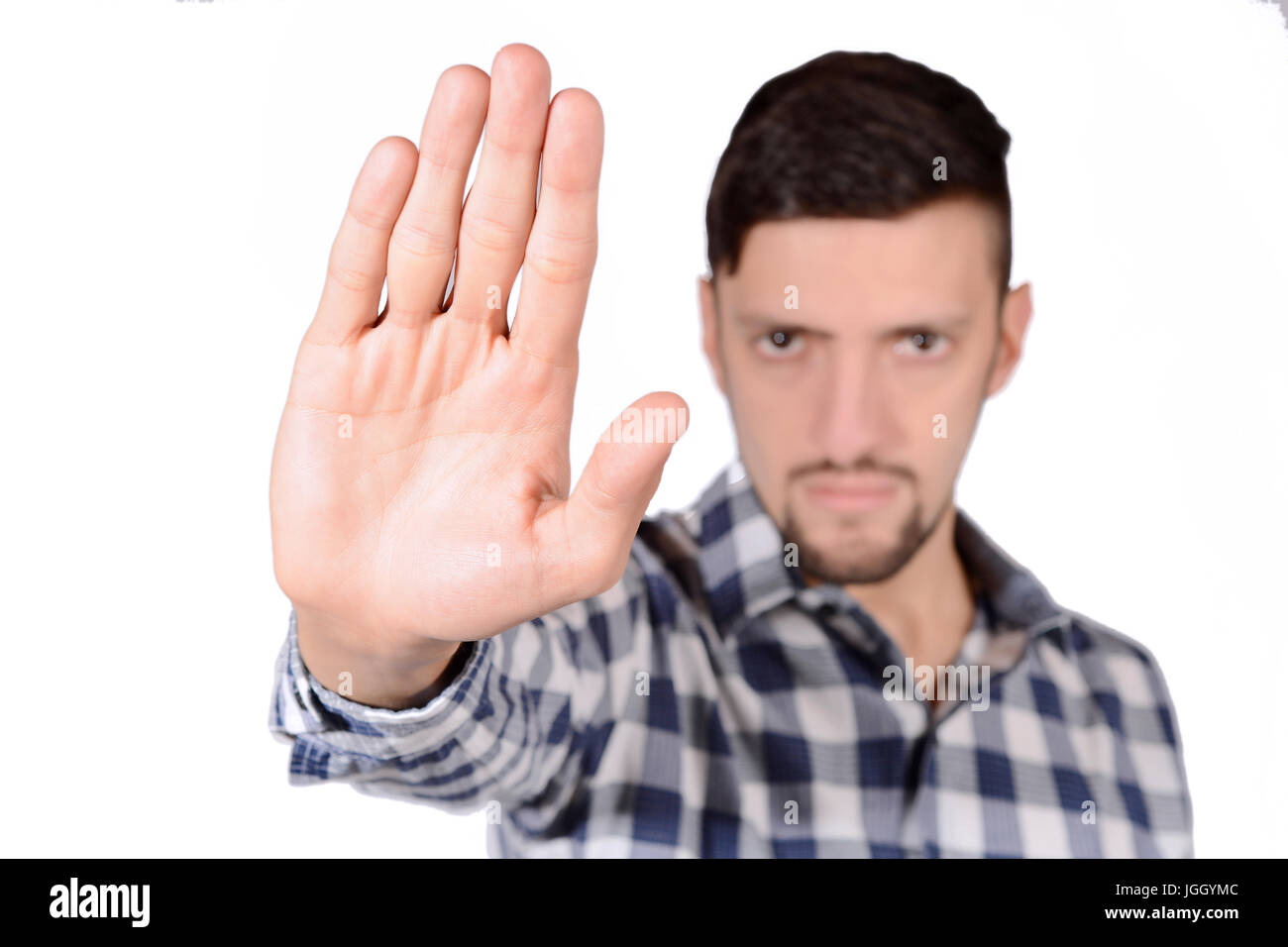 Giovane uomo facendo fermare il gesto con la mano. Isolato sullo sfondo bianco. Foto Stock