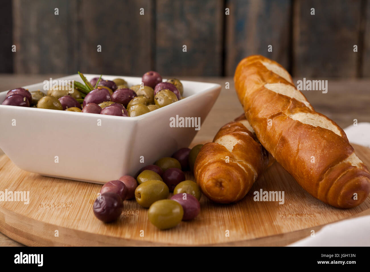 Le olive nel contenitore da pane sul tagliere Foto Stock