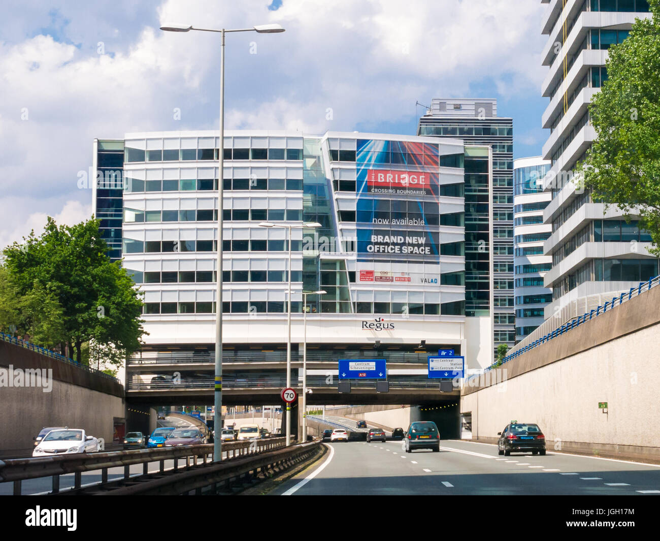 Il traffico su autostrada A12 anche chiamato Utrechtsebaan e moderno edificio a L'Aia, South-Holland, Paesi Bassi Foto Stock