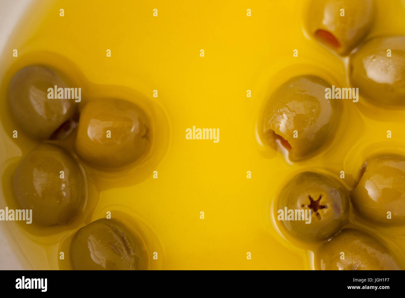 Close up di olive verdi con olio nel contenitore Foto Stock