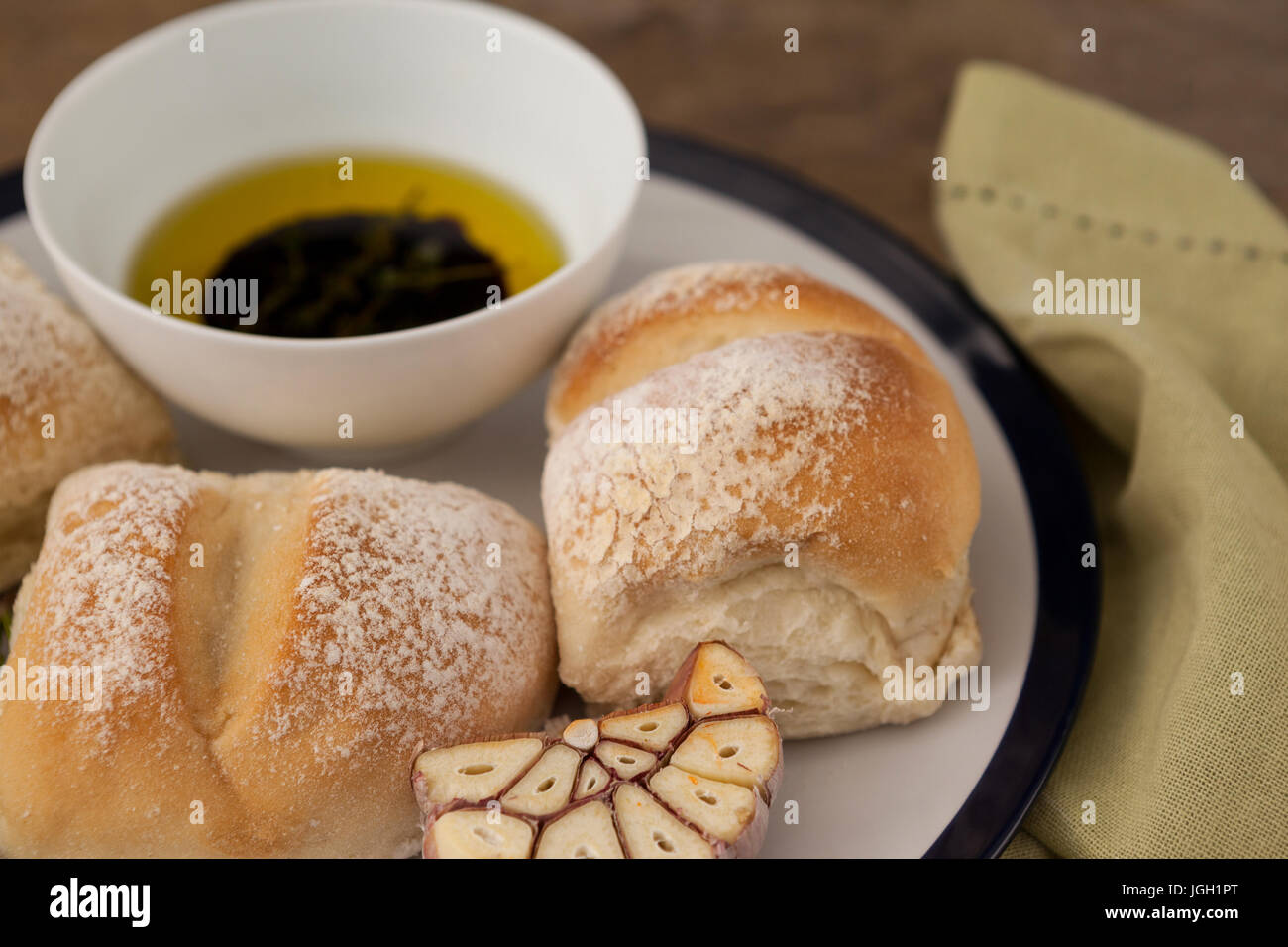 Close up di pane con olio d'oliva nella ciotola sulla piastra a tavola Foto Stock