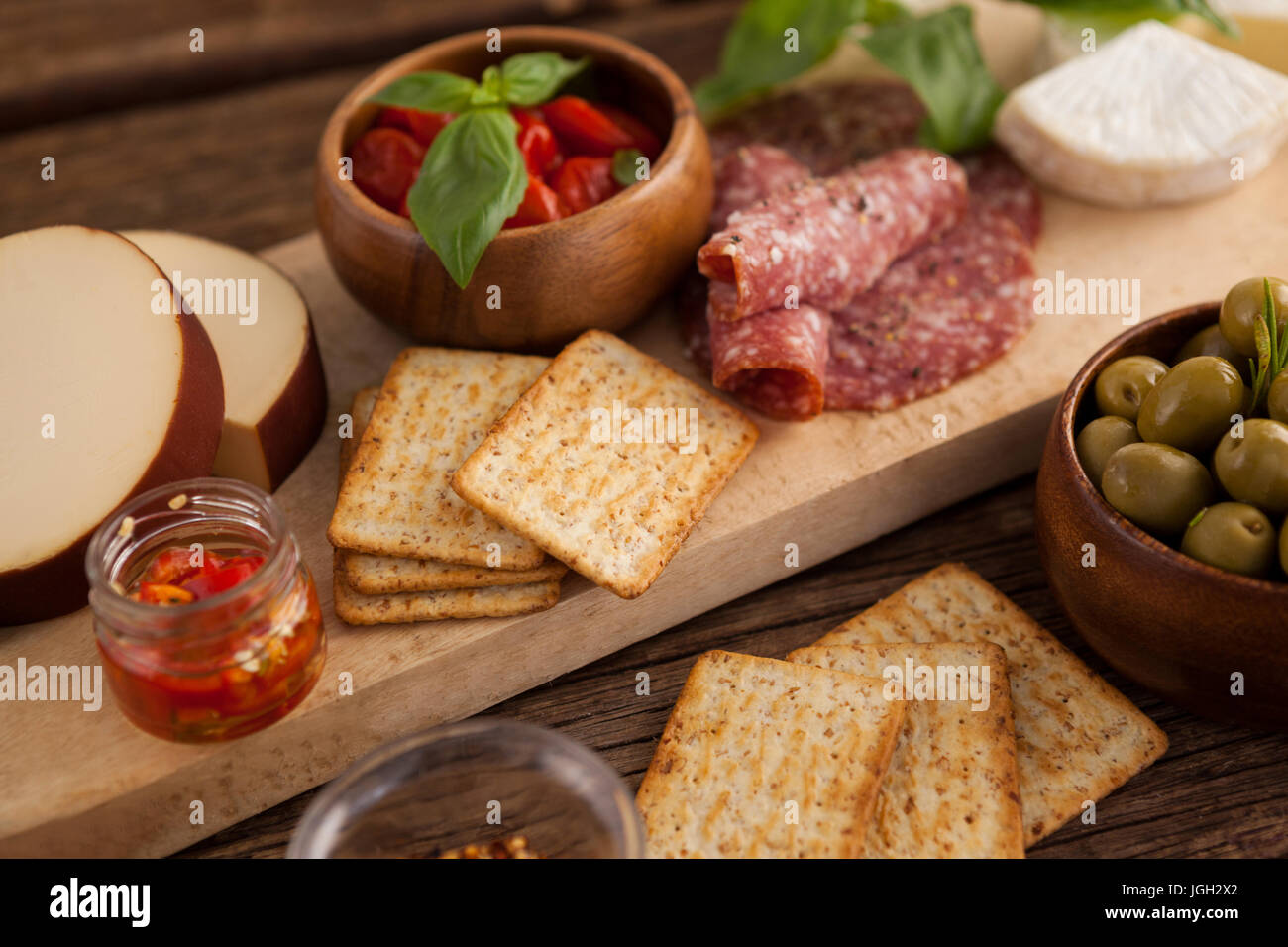 Close up di cracker con carne e olive su tavola Foto Stock