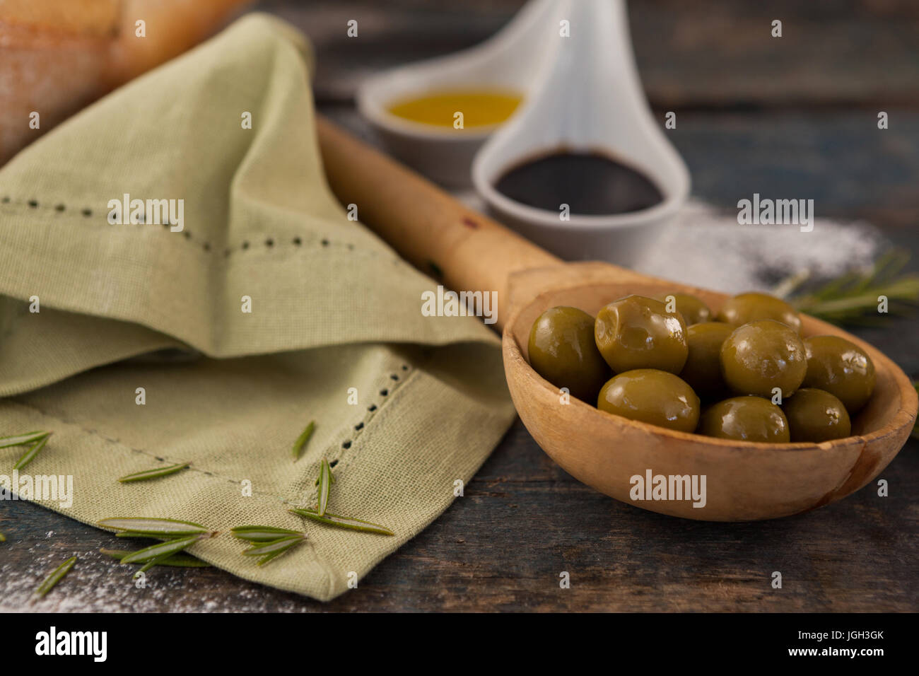 In prossimità delle olive verdi in cucchiaio con olio su tavola Foto Stock