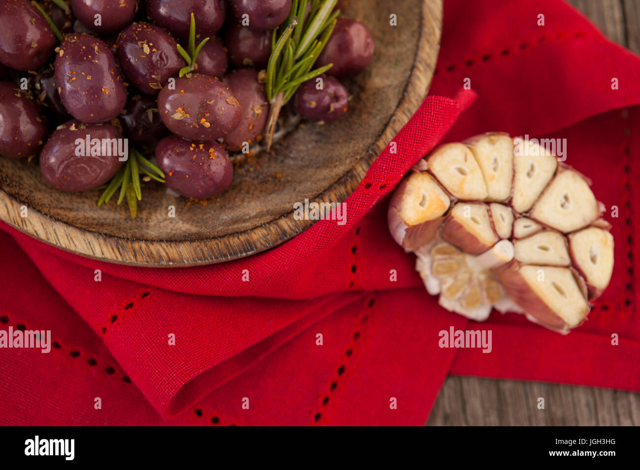 Close up di olive con rosmarino in vaso sul tovagliolo rosso Foto Stock