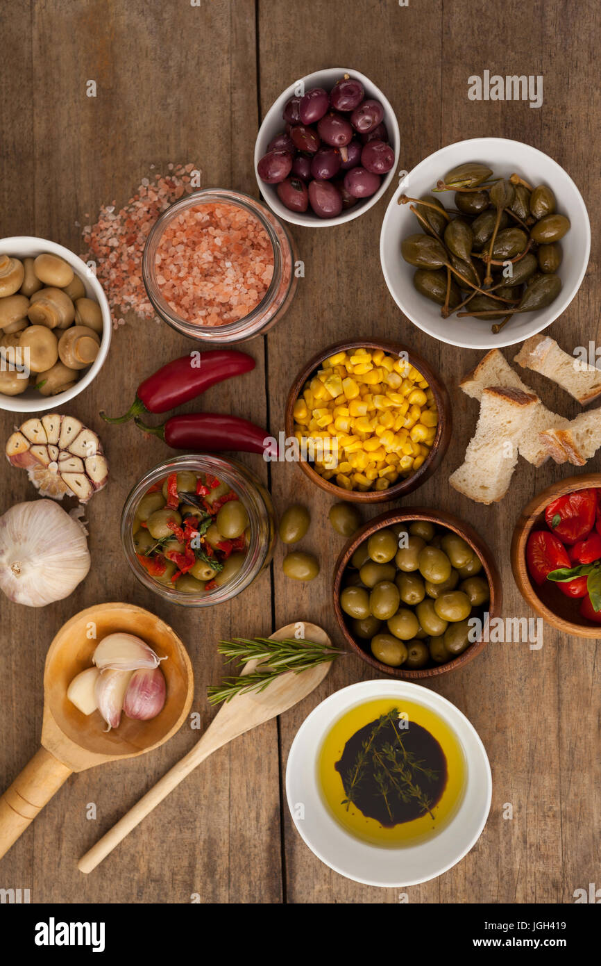 Vista aerea di olive con spezie e i calli con olio nella coppa sul tavolo Foto Stock