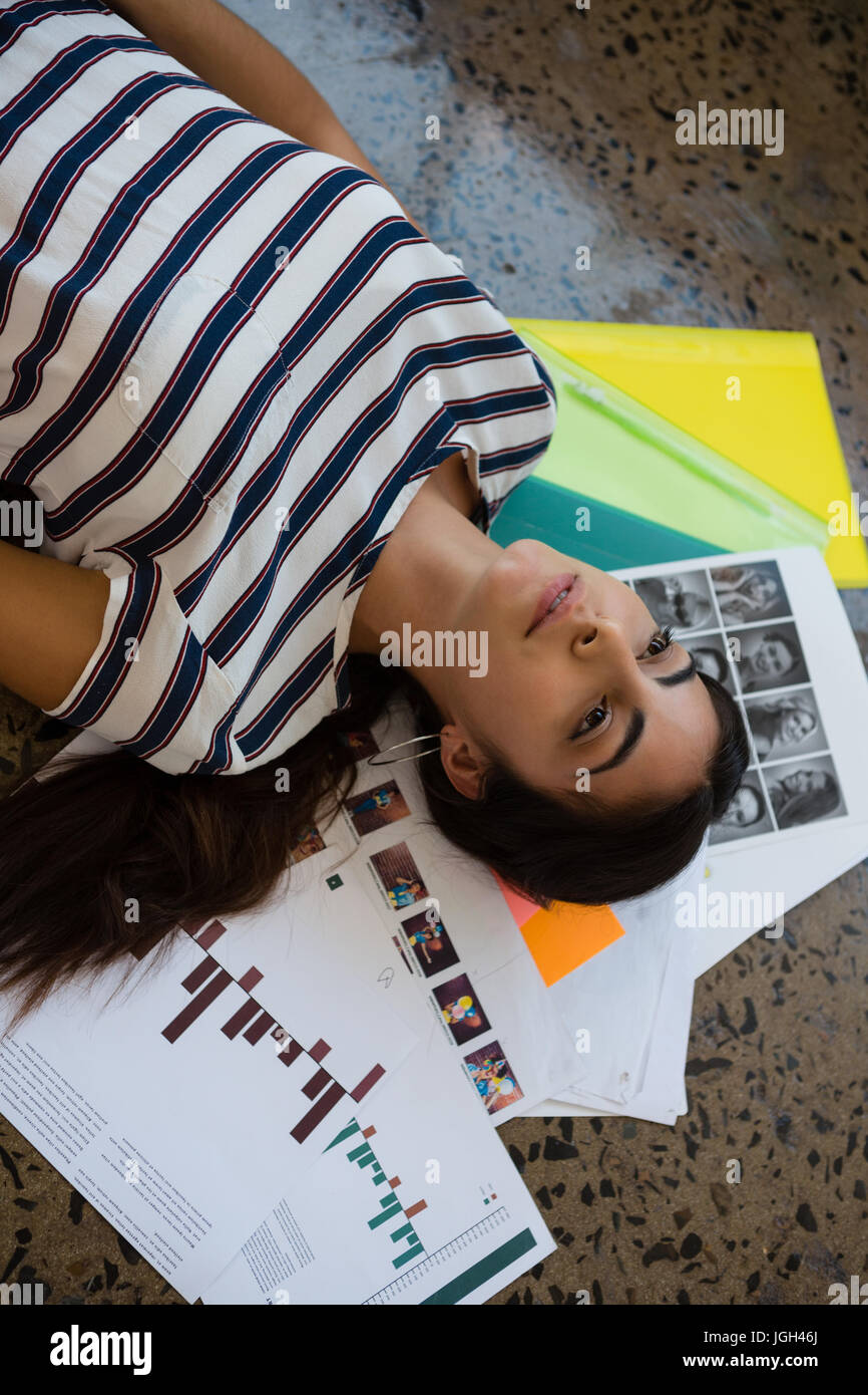 Alta vista angolare di pensosa giovane donna sdraiata su documenti presso il creative office Foto Stock