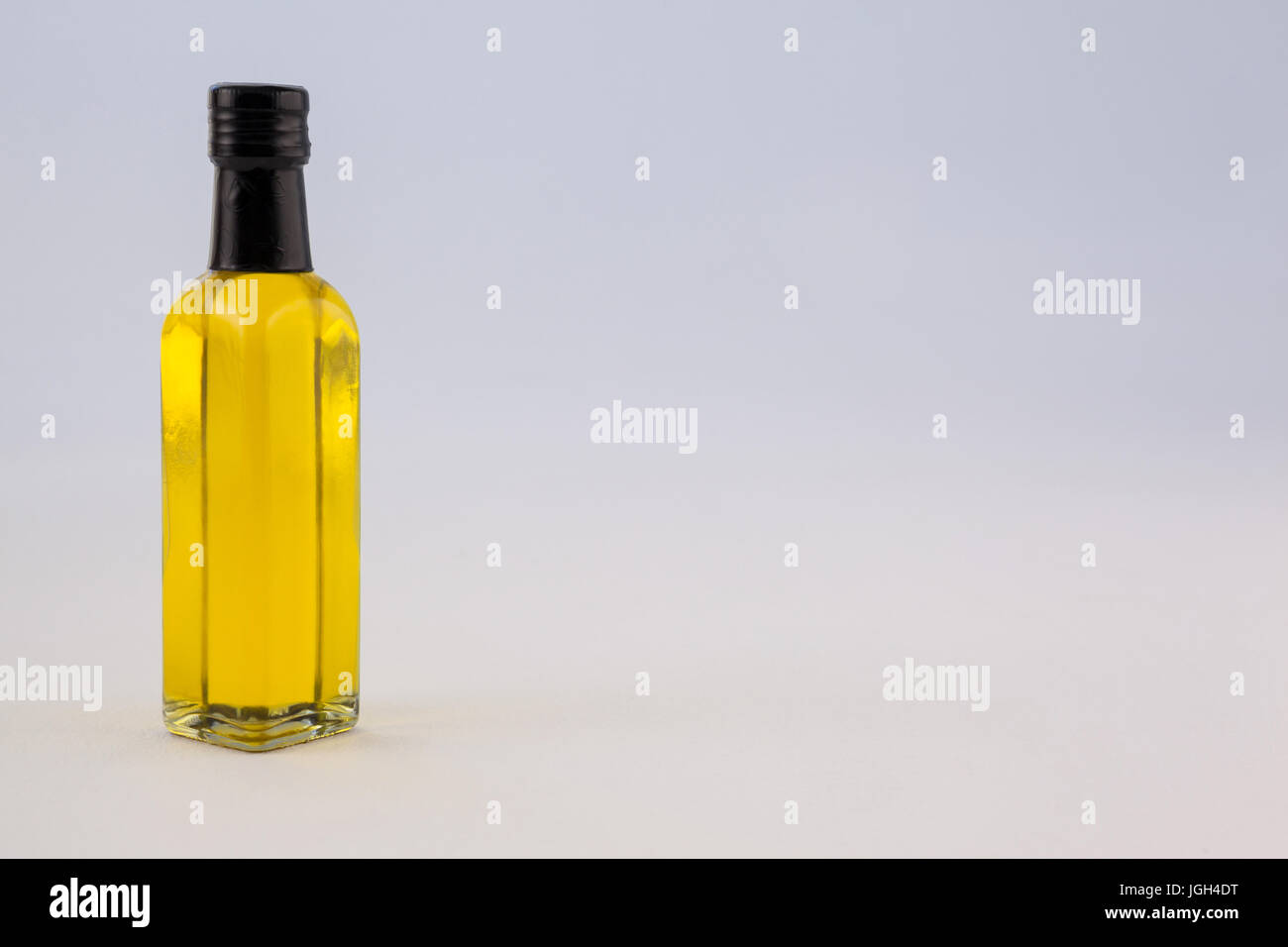 Olio giallo bottiglia contro il muro grigio Foto Stock