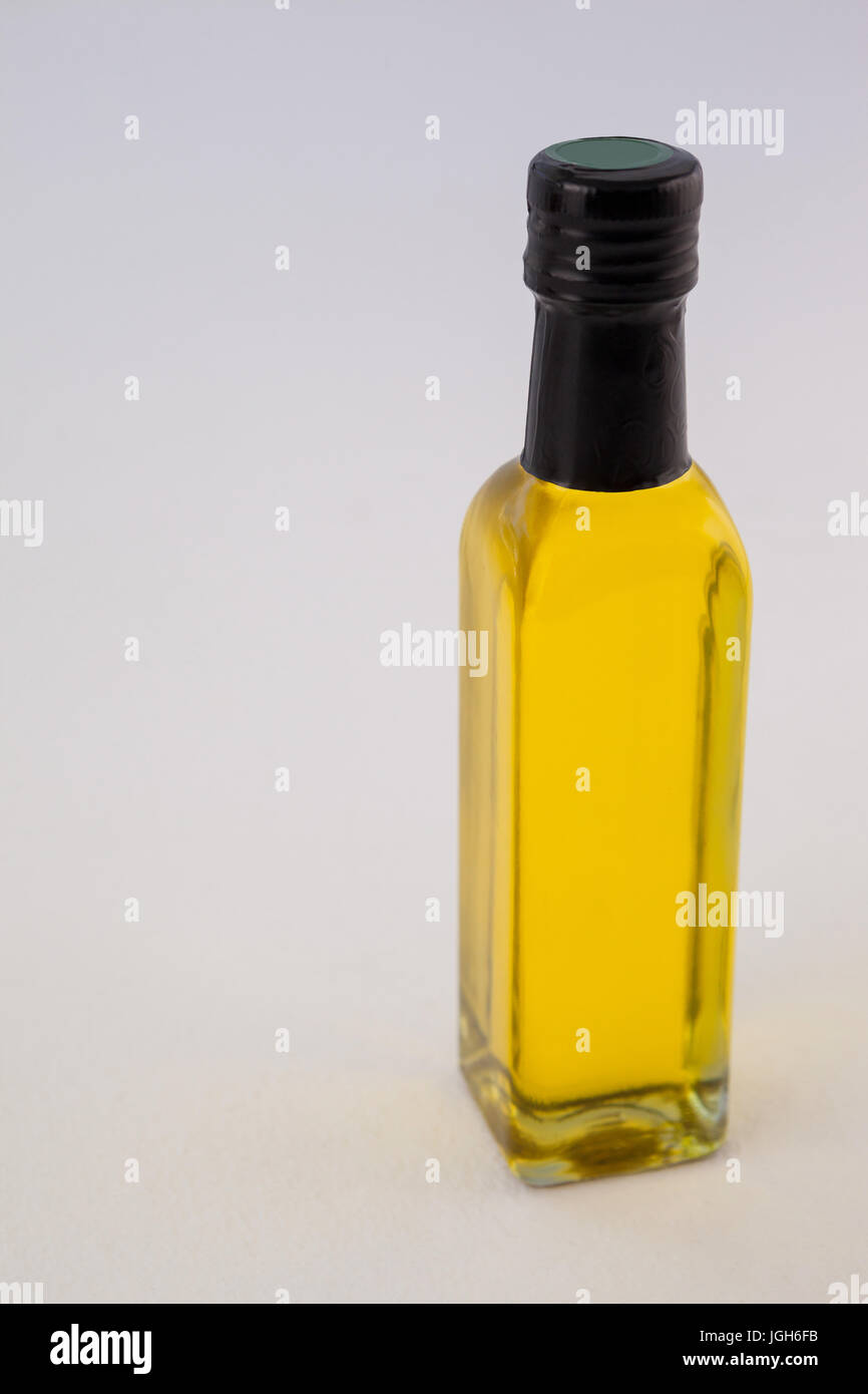 Alta Vista angolo giallo bottiglia di olio con coperchio contro la parete Foto Stock