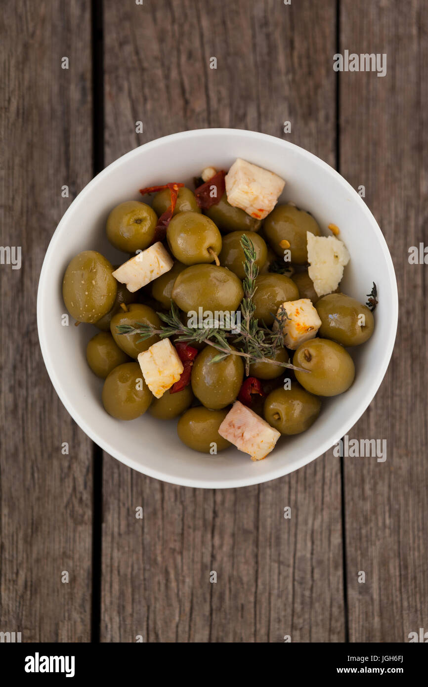Direttamente al di sopra di shot per le olive con formaggio servita nella ciotola sul tavolo di legno Foto Stock