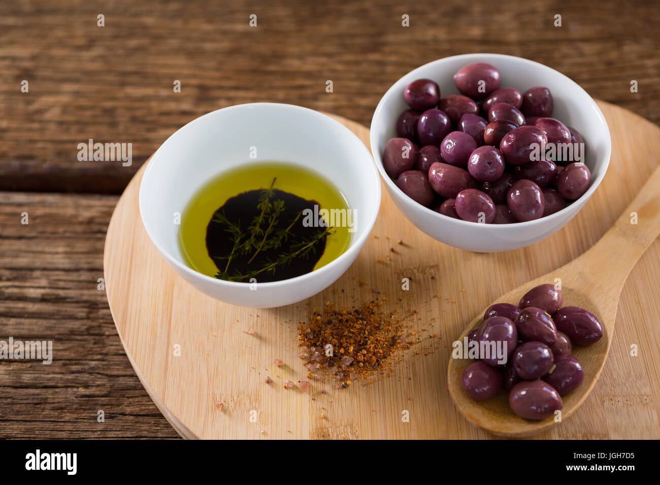 Close-up di porpora, olive, olio e il cucchiaio di legno sul tavolo Foto Stock