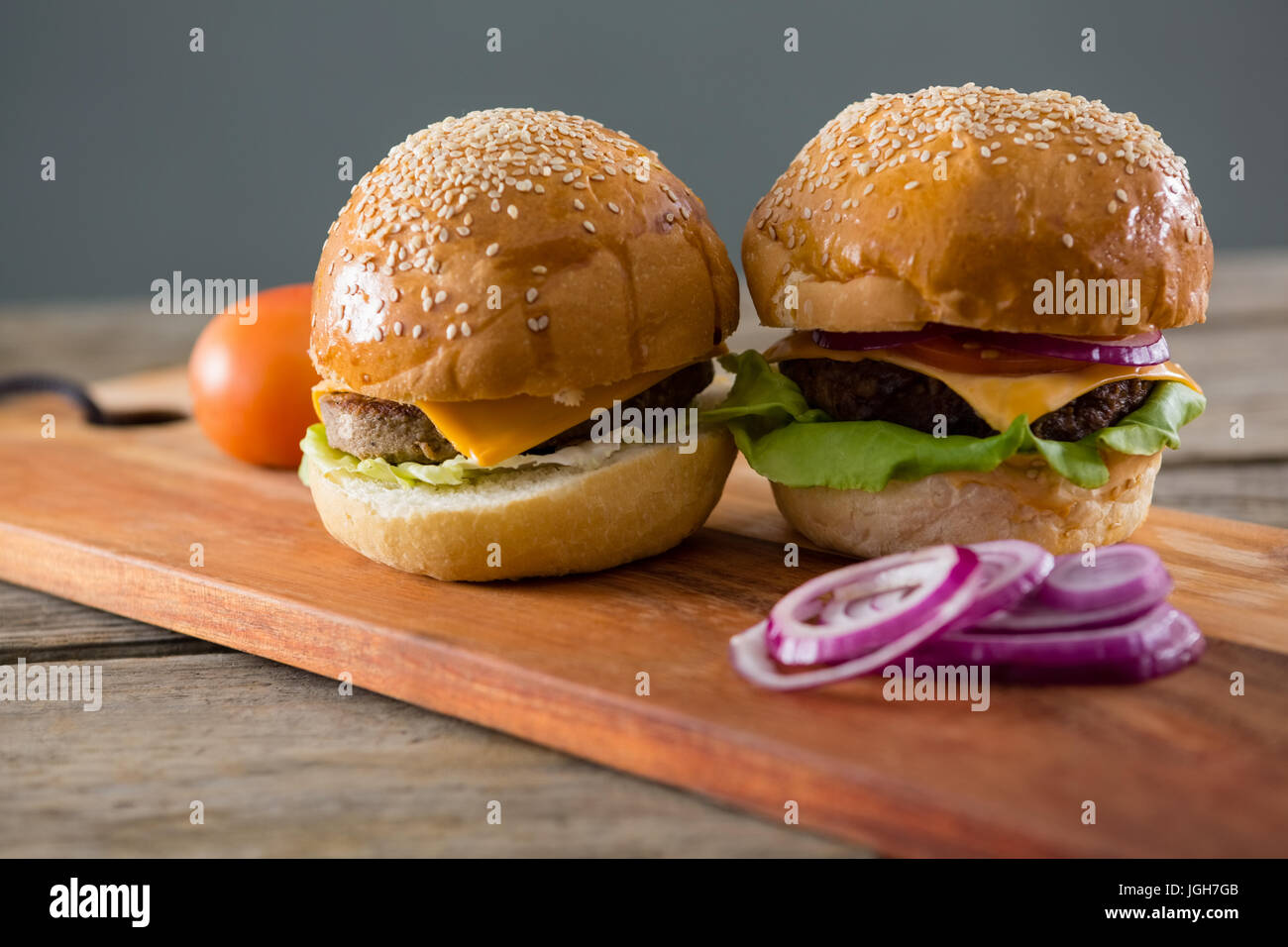 Cheeseburger con cipolla e pomodoro sul bordo di taglio Foto Stock