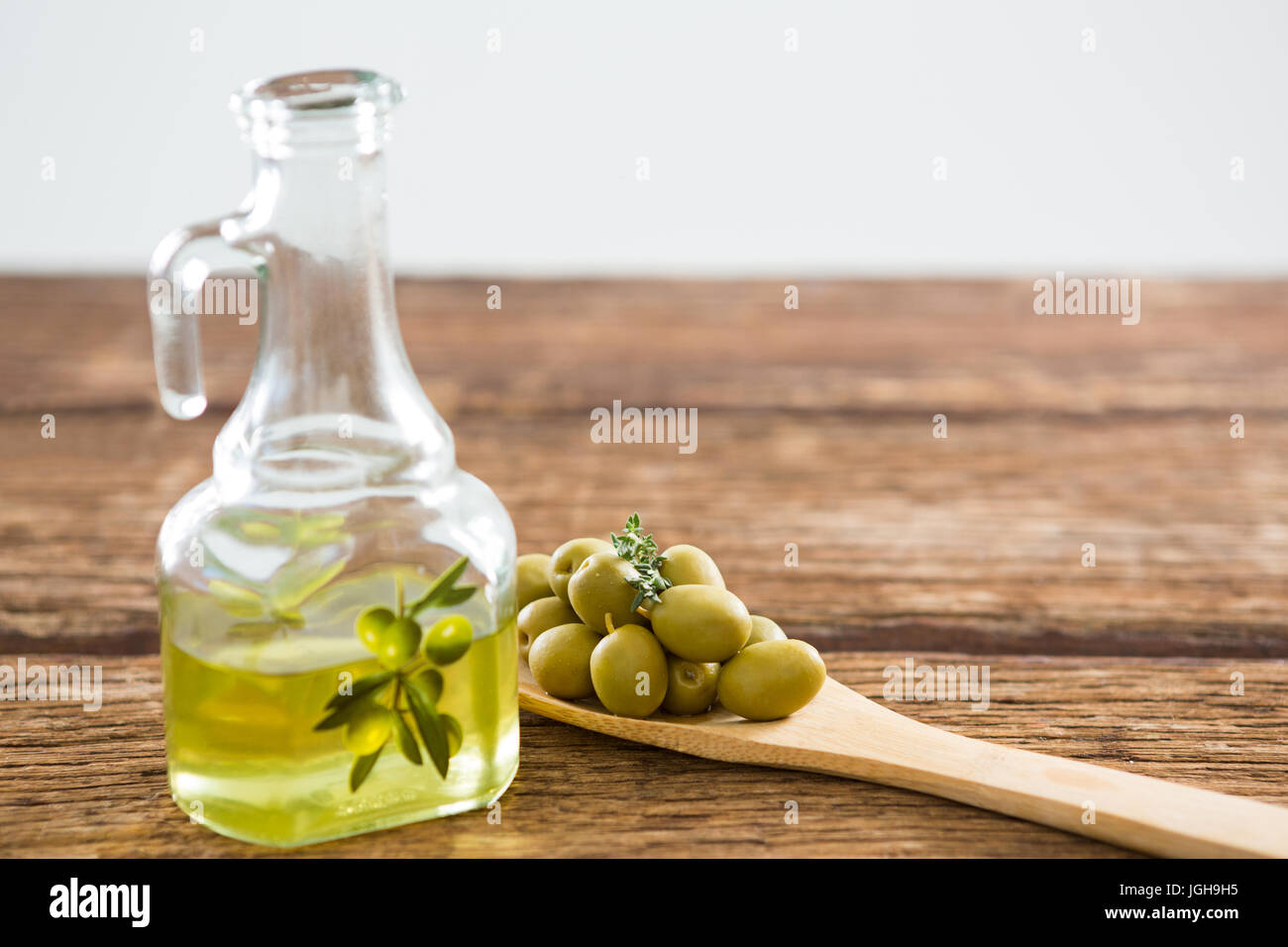 Marinata di olive e di olio su tavola in legno Foto Stock