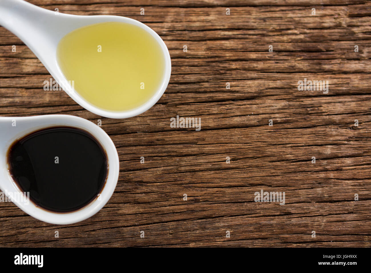 Close-up di olio di oliva e aceto balsamico in cucchiaio sul tavolo Foto Stock