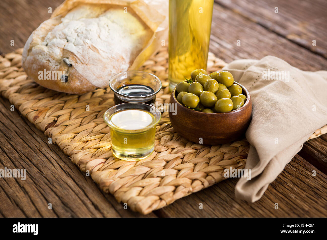 Close-up di olive marinate, bottiglia di olio e sale sul tagliere Foto Stock