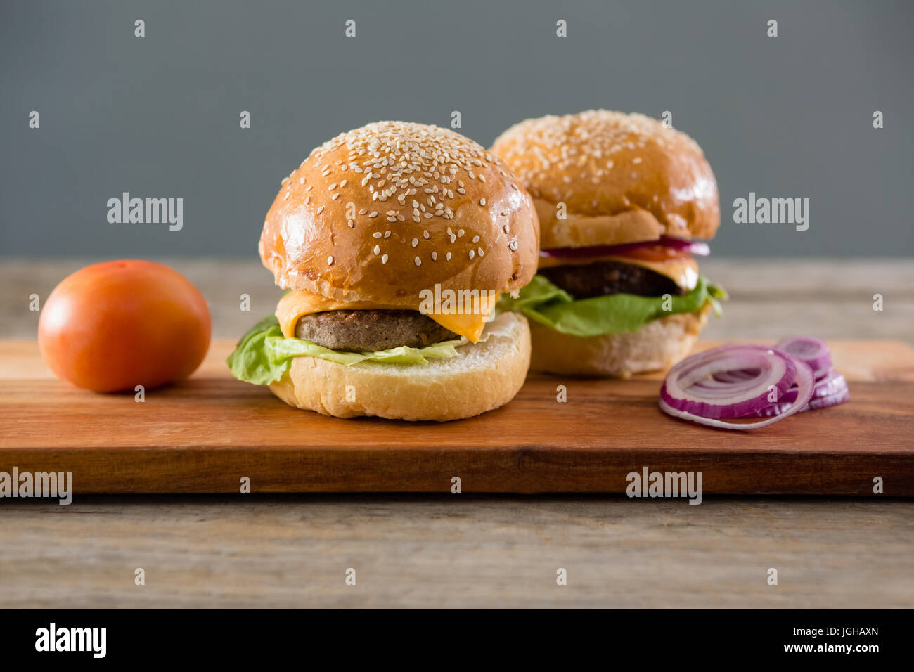 Close up cheeseburger con cipolla e pomodoro sul bordo di taglio Foto Stock