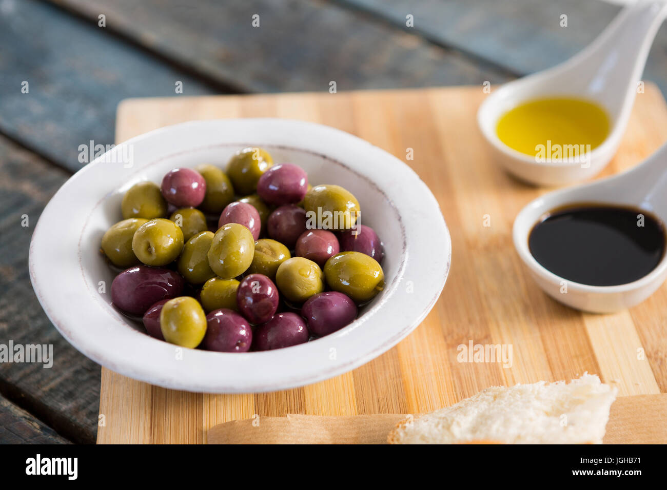 Close-up di olive marinate con olio d'oliva sul tagliere Foto Stock