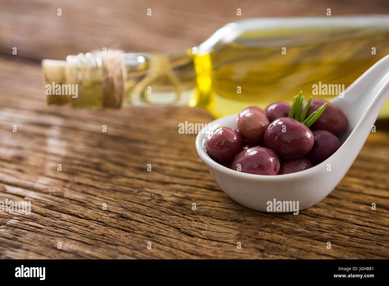 Close-up di marinato e olio d'oliva Bottiglia sul tavolo di legno Foto Stock