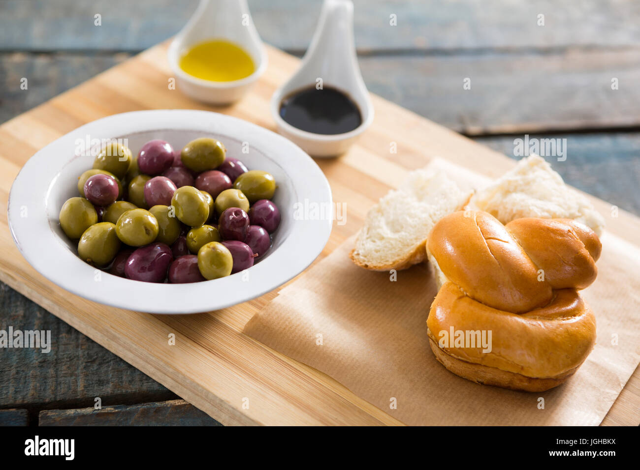 Olive marinate con pane e olio d'oliva sul tagliere Foto Stock