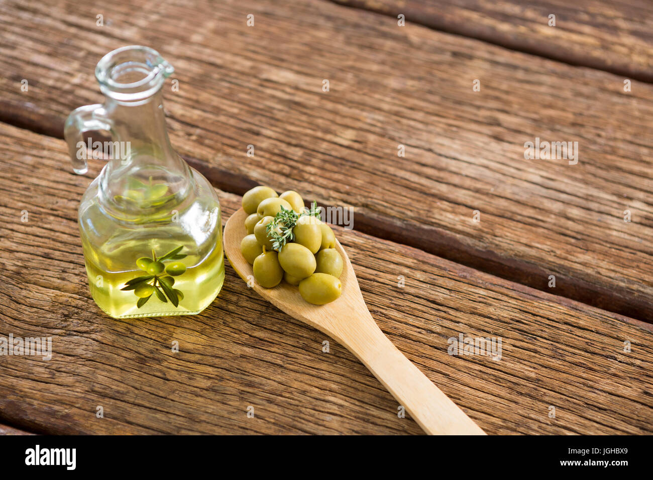 Marinata di olive e di olio su tavola in legno Foto Stock