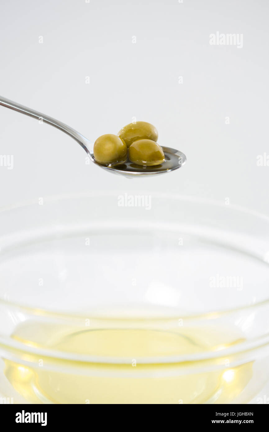 Olive in cucchiaio contro uno sfondo bianco Foto Stock