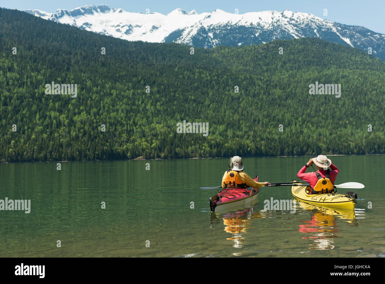 Vista posteriore del giovane kayak nel lago di montagna Foto Stock