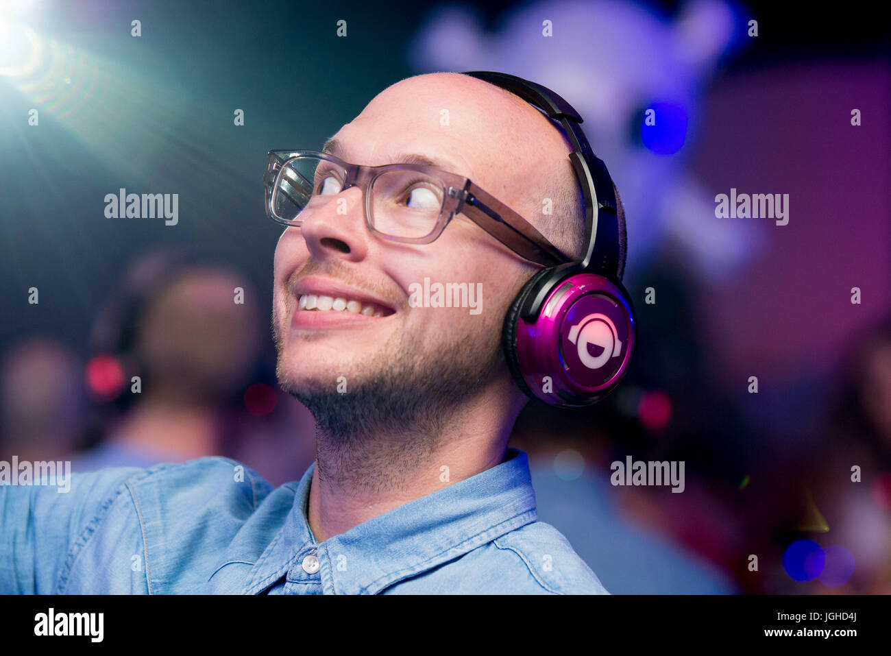L'uomo gode di musica sul suo cuffie durante una discoteca silenziosa Foto Stock