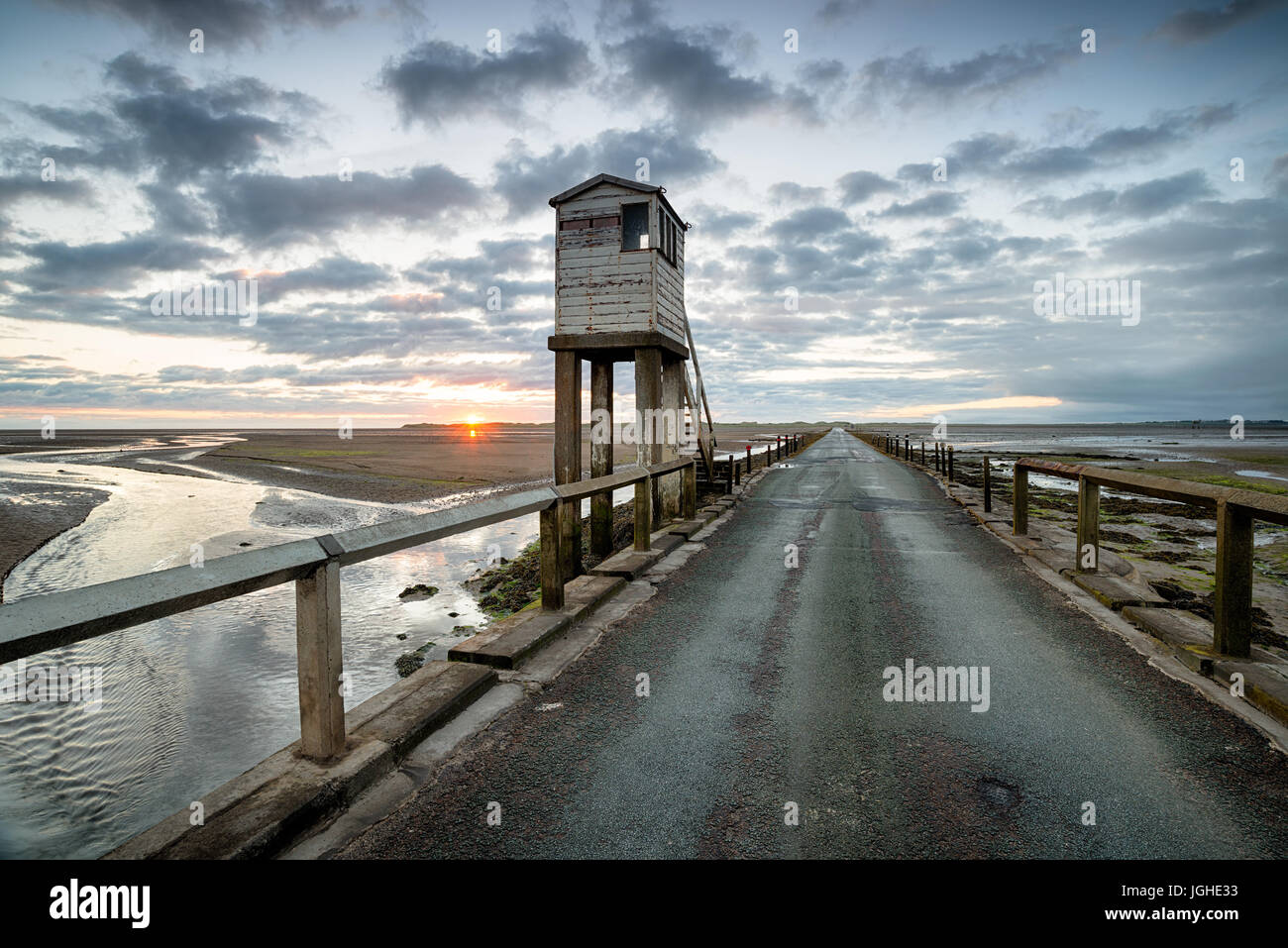 Alba sul tidal causeway e rifugio che conduce all'isola di Lindisfarne sulla costa Northumbrian Foto Stock