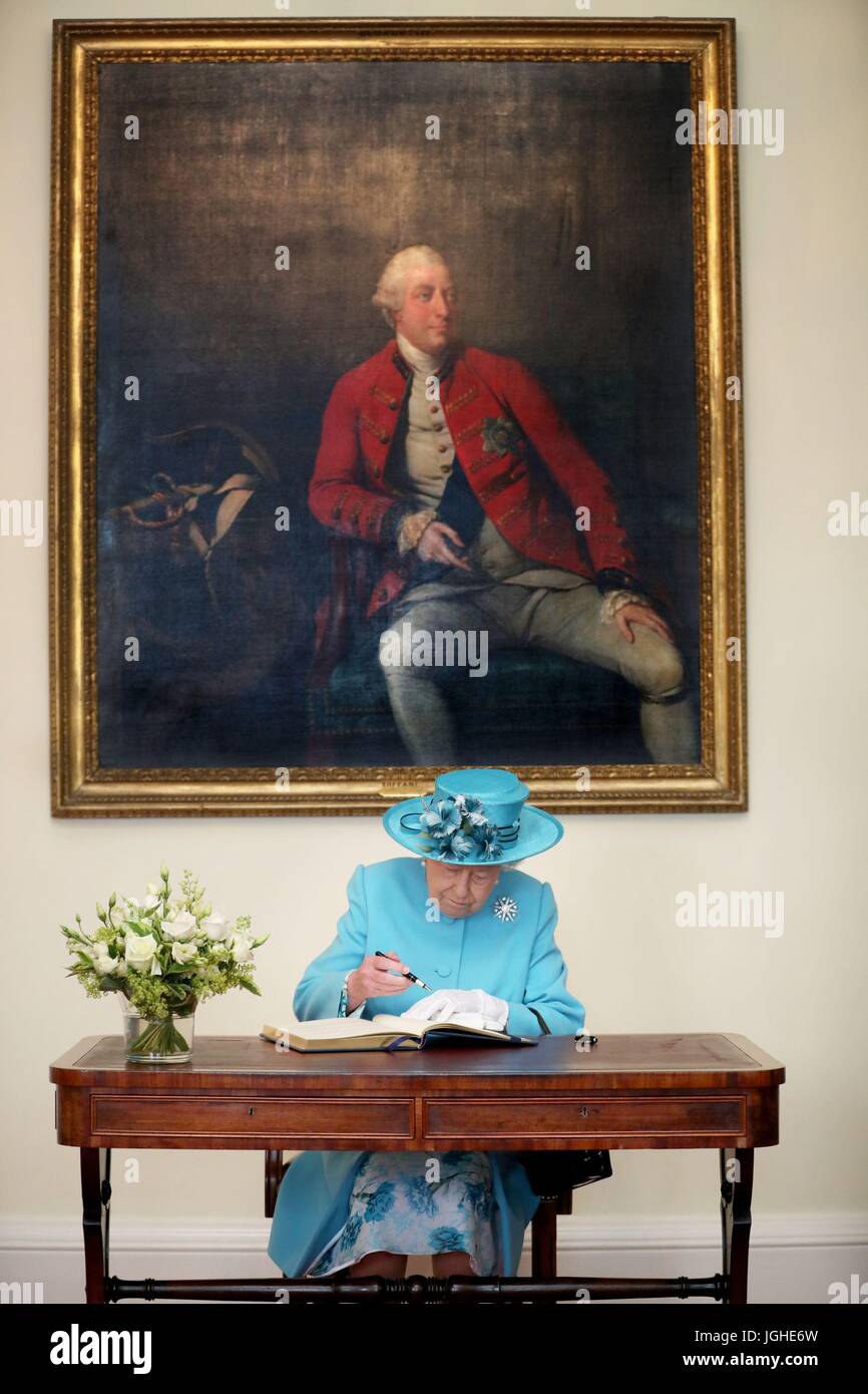 Queen Elizabeth II firma il libro dei visitatori, sotto un ritratto di Re Giorgio III, durante una visita alla Royal Society di Edimburgo dove ha presentato Royal medaglie al Professor Peter Boyle e il Professor Tessa Holyoake. Foto Stock