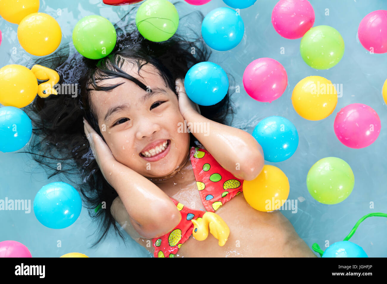 Felice cinese asiatici bambina a giocare nella piscina gonfiabile  all'interno della casa Foto stock - Alamy