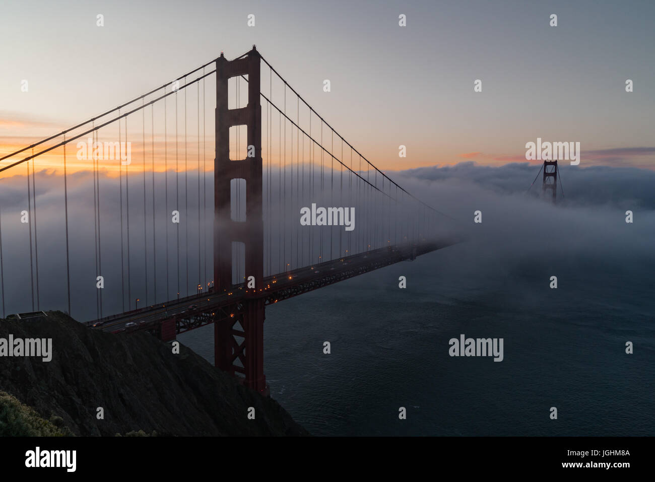 Sunrise e la nebbia sopra il Golden Gate Bridge di San Francisco, California Foto Stock