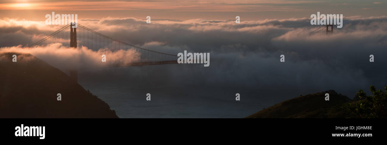 Sunrise e la nebbia sopra il Golden Gate Bridge di San Francisco, California Foto Stock
