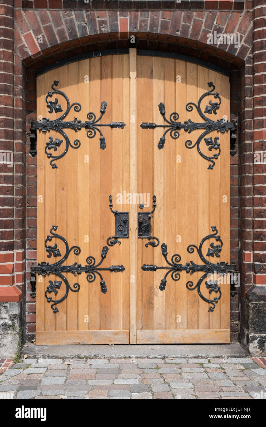 Vecchia porta di legno con metallo la maniglia dello sportello e la decorazione battuto Foto Stock