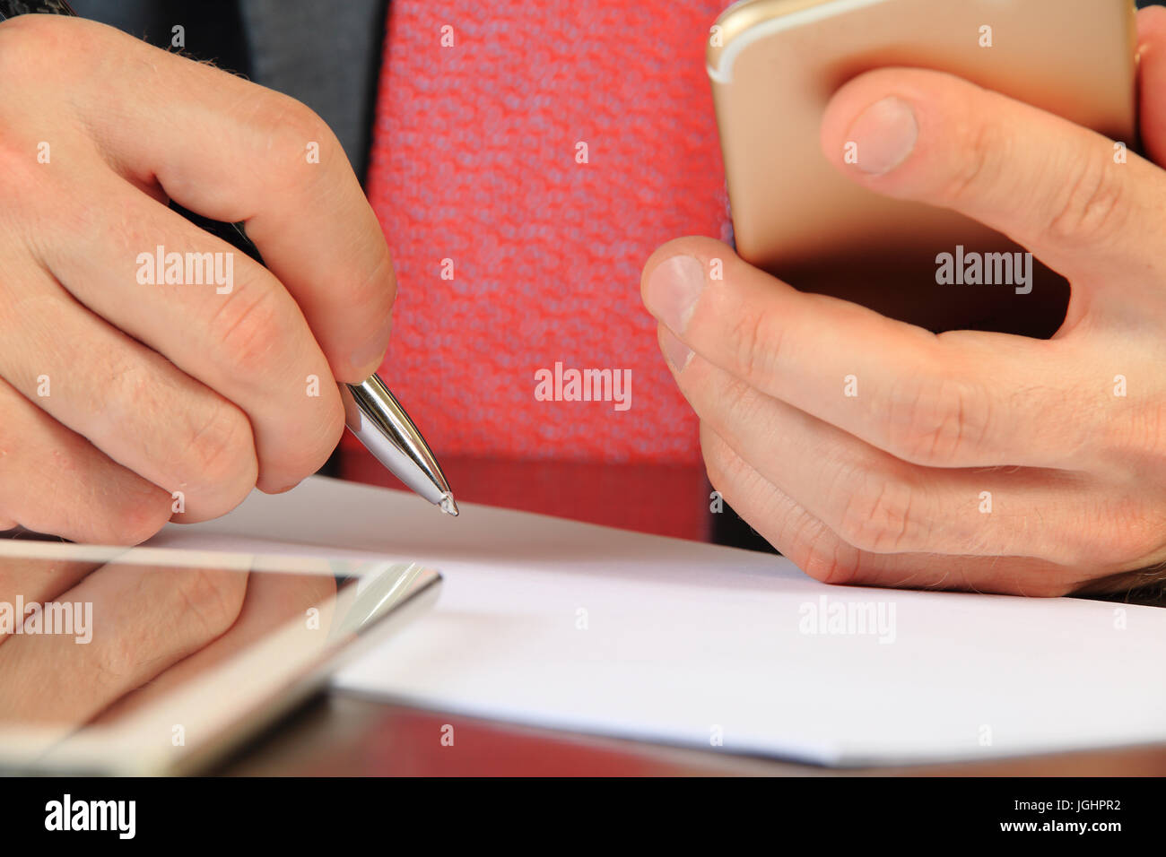 Imprenditore mani con lo smartphone e penna di close-up. Uomo d'affari alla ricerca di partner on-line. Ricerca di partner commerciali nozione. Foto Stock