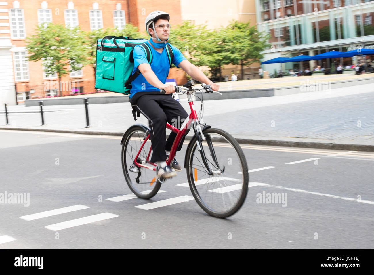 Servizi di corriere in bicicletta a consegnare il cibo in città Foto Stock