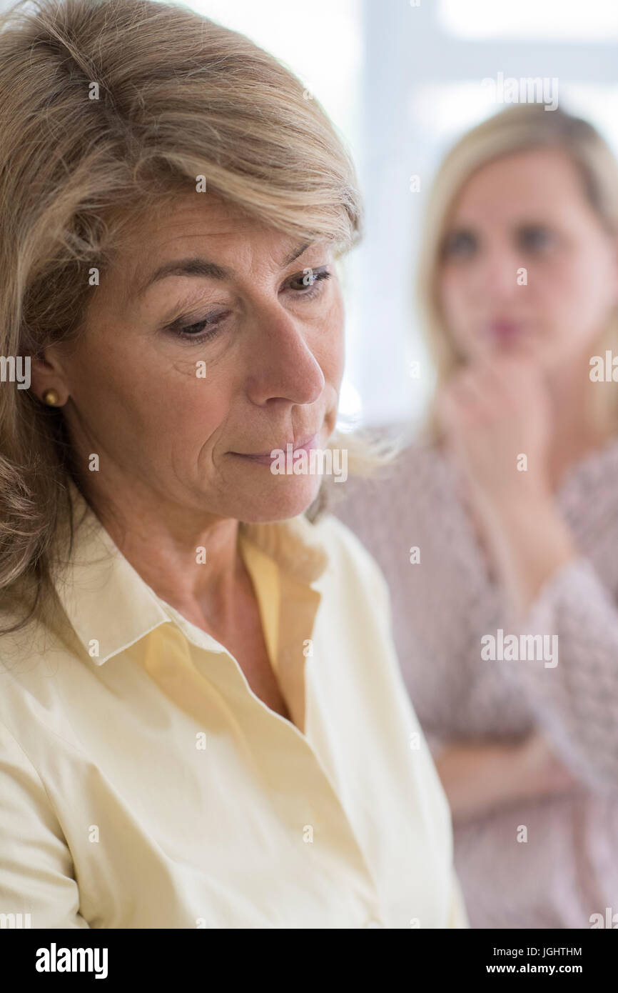 Grave donna matura con figlia adulta a casa Foto Stock