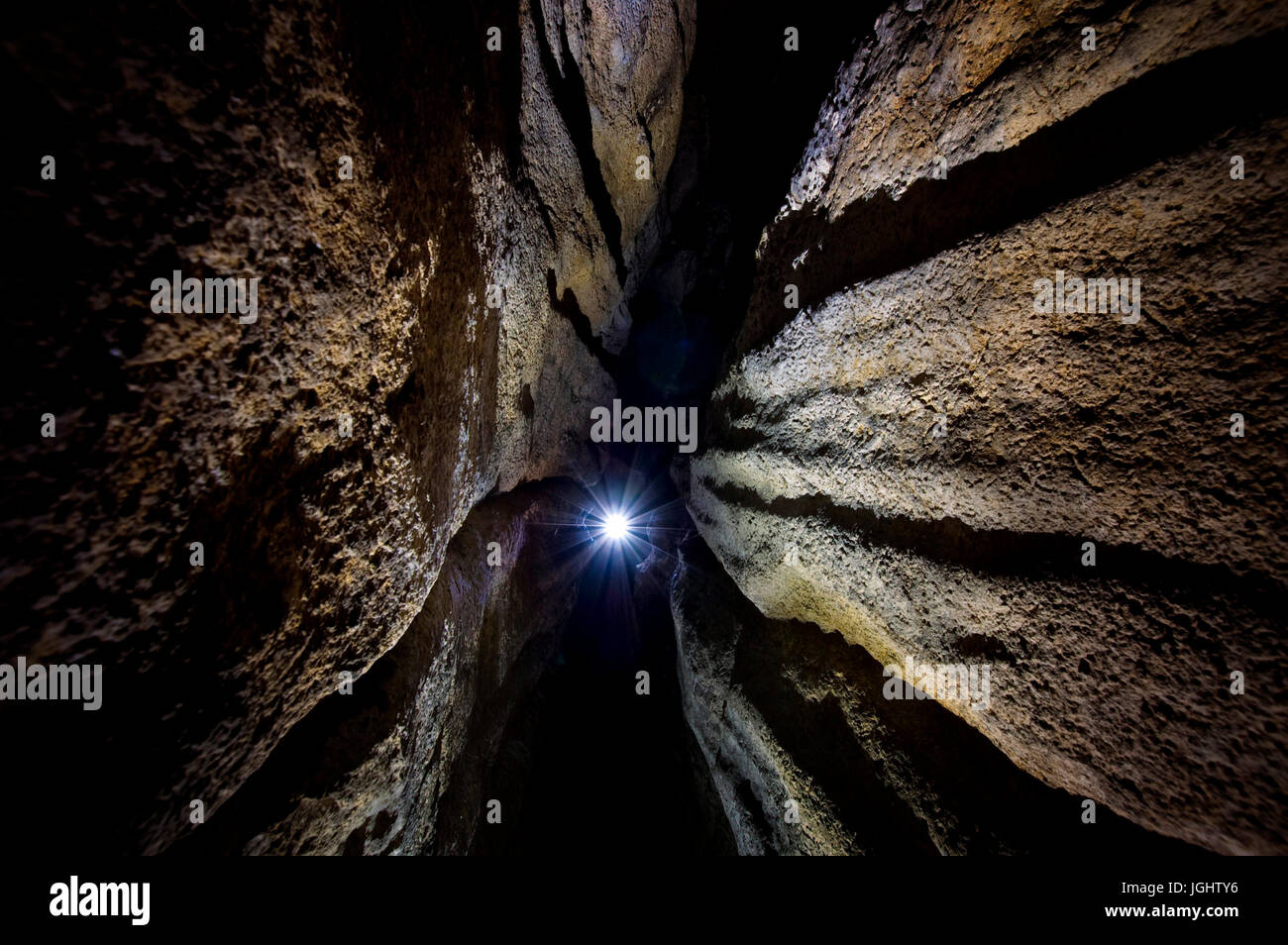 La luce all'ingresso di dark grotta sotterranea tunnel Foto Stock