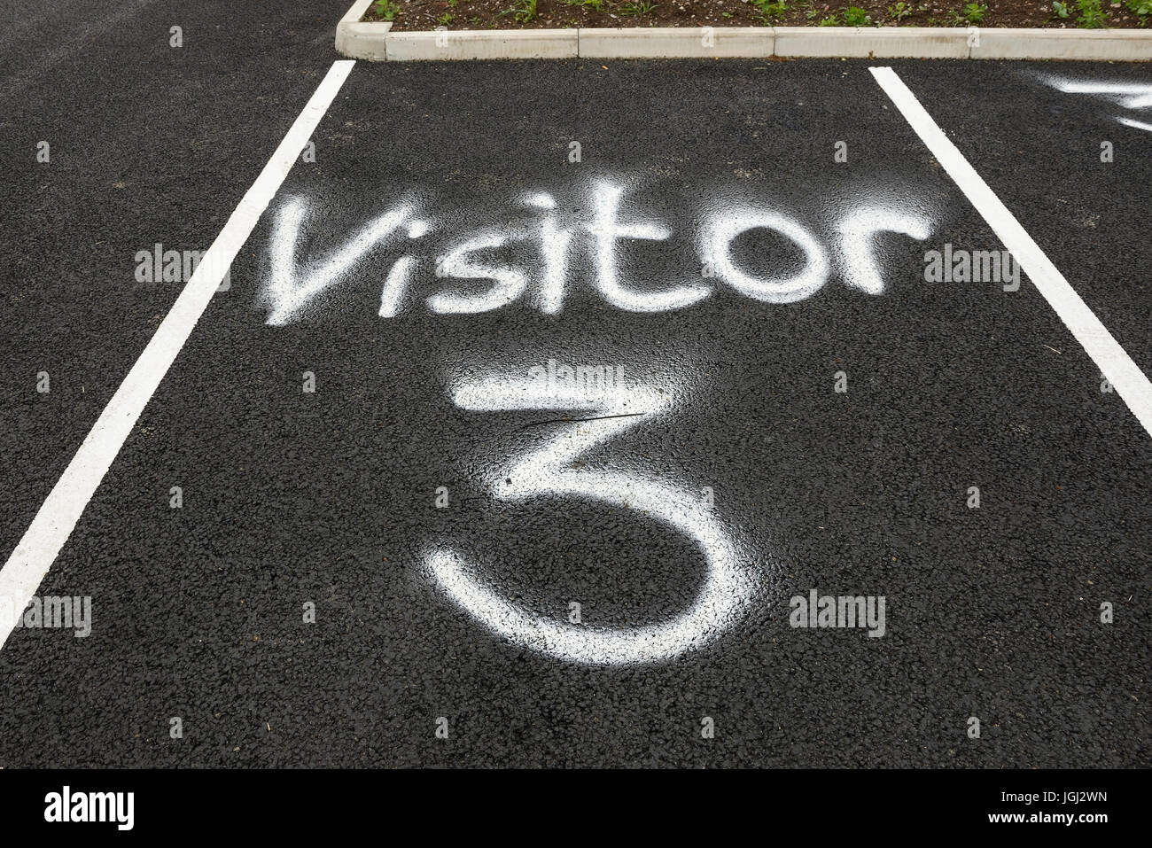 Dipinto a mano visitatore spazio per parcheggiare in un parcheggio Foto Stock