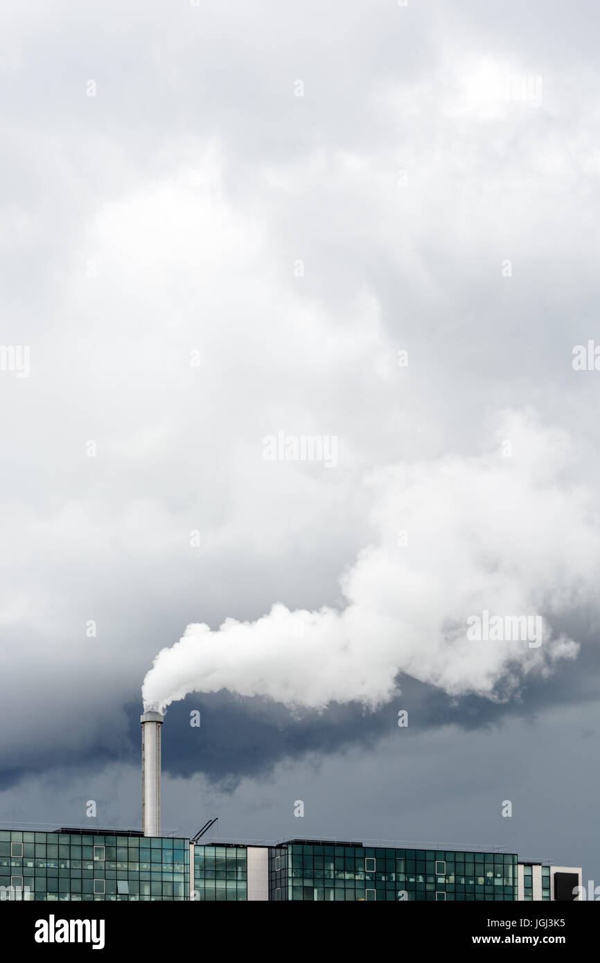 Industriale emissione di fumo dal camino di fabbrica sotto un cielo tempestoso. Foto Stock