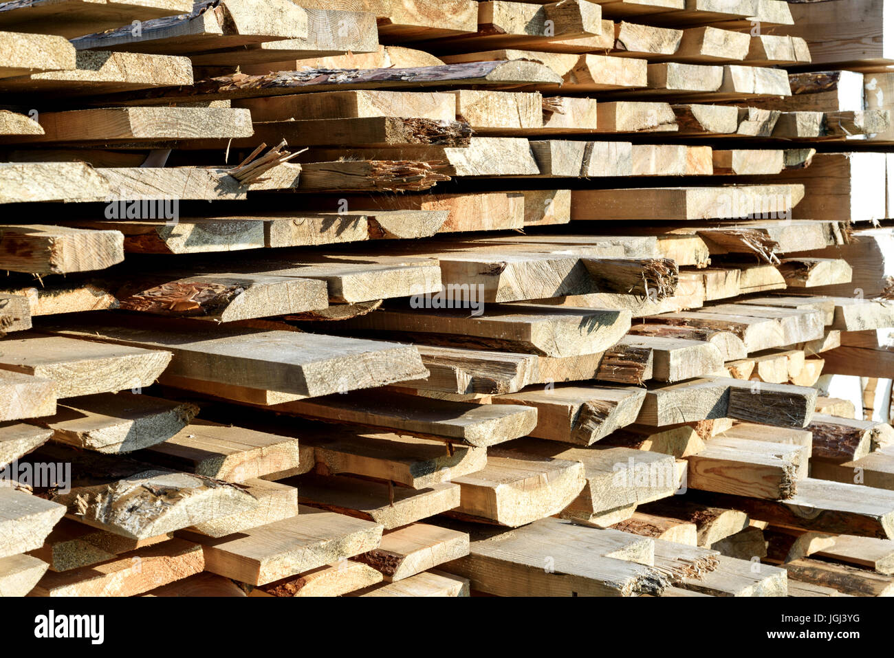 Tagliare grossolanamente pile di tavole in legno per la casa e il design costruzione in presenza di luce solare Foto Stock