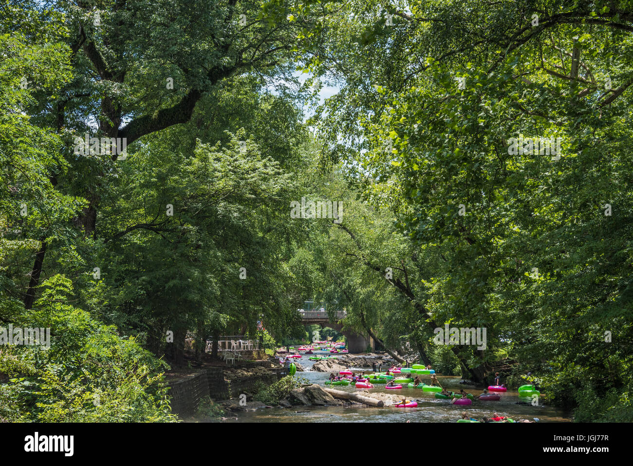 Estate Tubing sul fiume Chattahoochee sotto un baldacchino di alberi attraverso il centro cittadino di Helen, Georgia. (USA) Foto Stock