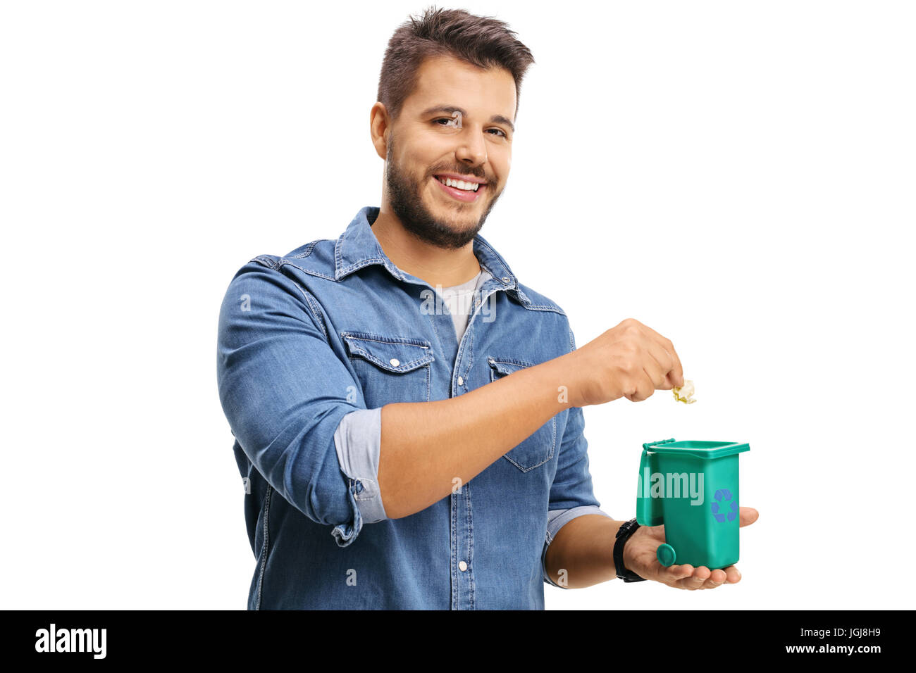 Giovane uomo lanciando un pezzo di immondizia in un piccolo contenitore di riciclaggio isolati su sfondo bianco Foto Stock