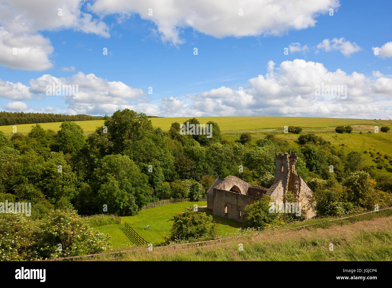 Wharram percy rovine della chiesa da un lato di una collina sotto un cielo di estate blu nel yorkshire wolds circondata da una pittoresca campagna Foto Stock